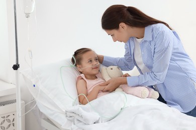 Photo of Mother and her little daughter on bed in hospital