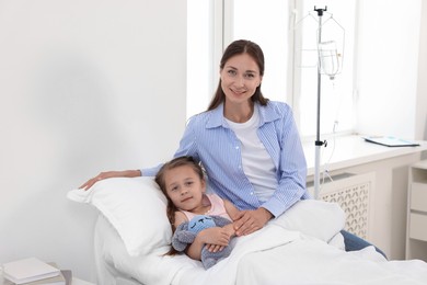 Mother and her little daughter on bed in hospital