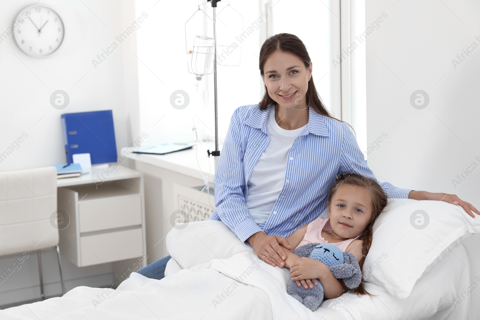 Photo of Mother and her little daughter on bed in hospital