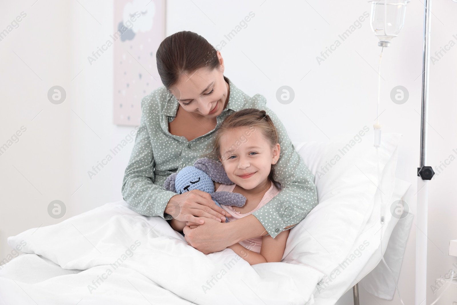 Photo of Mother and her little daughter on bed in hospital