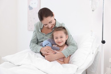 Mother and her little daughter on bed in hospital