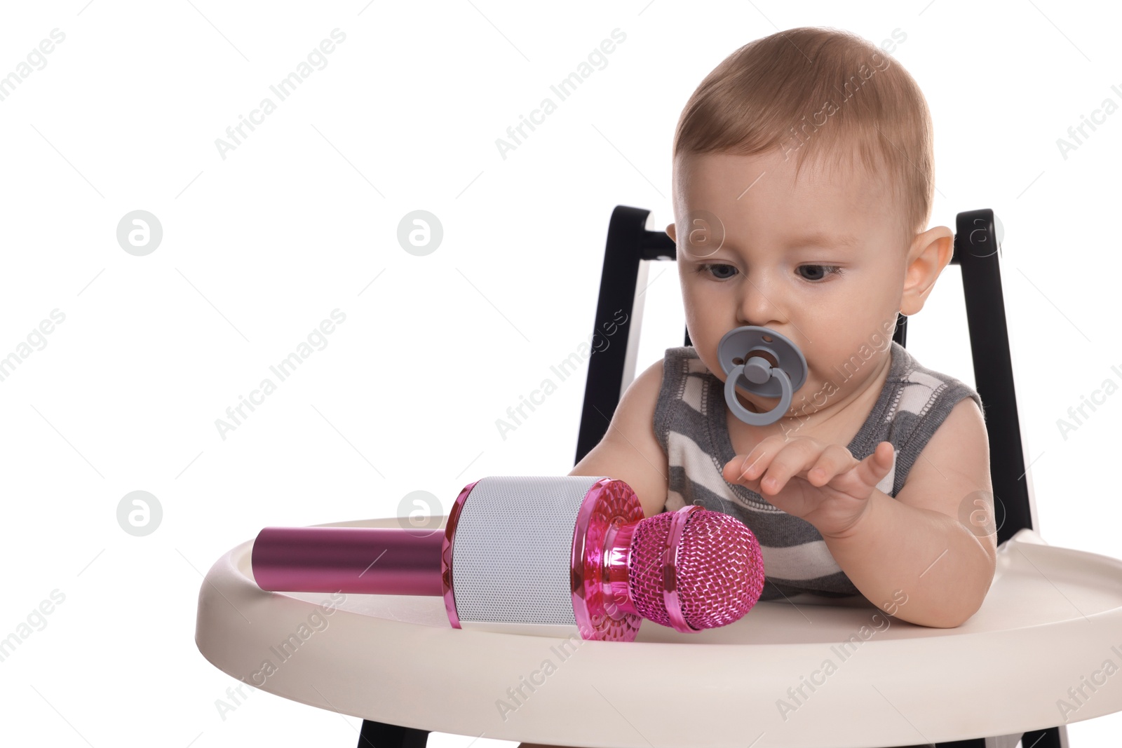 Photo of Cute little baby with pacifier and microphone in high chair on white background