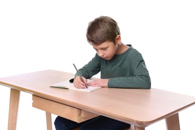 Photo of Boy with incorrect posture and notebook at wooden desk on white background