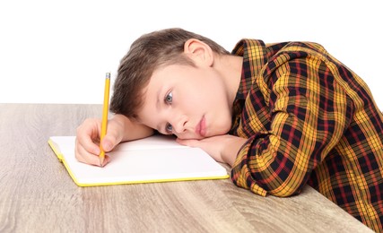 Photo of Boy with incorrect posture and notebook at wooden desk on white background