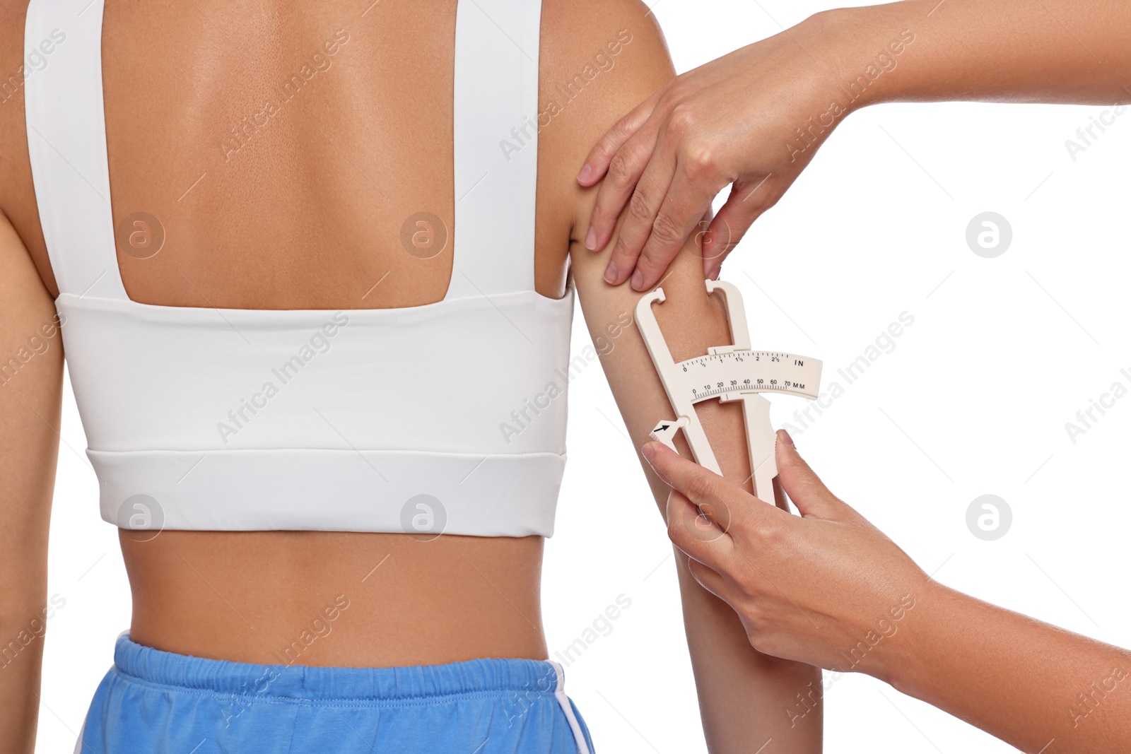 Photo of Nutritionist measuring woman's body fat with caliper on white background, closeup