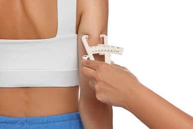 Photo of Nutritionist measuring woman's body fat with caliper on white background, closeup