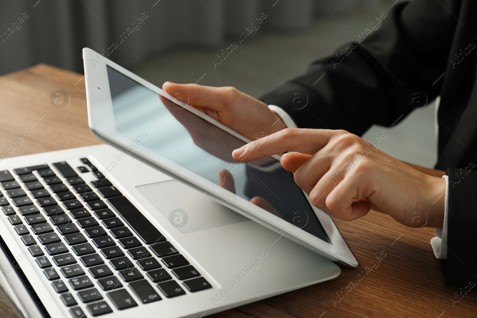 Photo of Businesswoman using tablet at table indoors, closeup. Modern technology