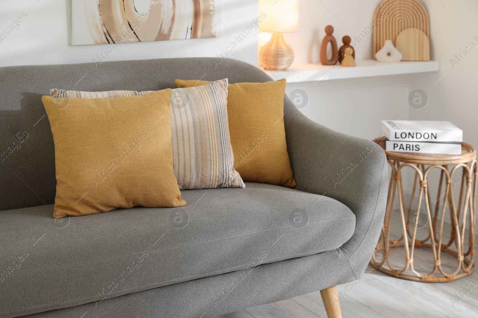 Photo of Different soft pillows on gray sofa in living room