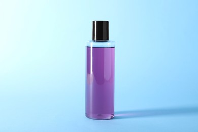 Photo of Shampoo in bottle on light blue background. Personal care product