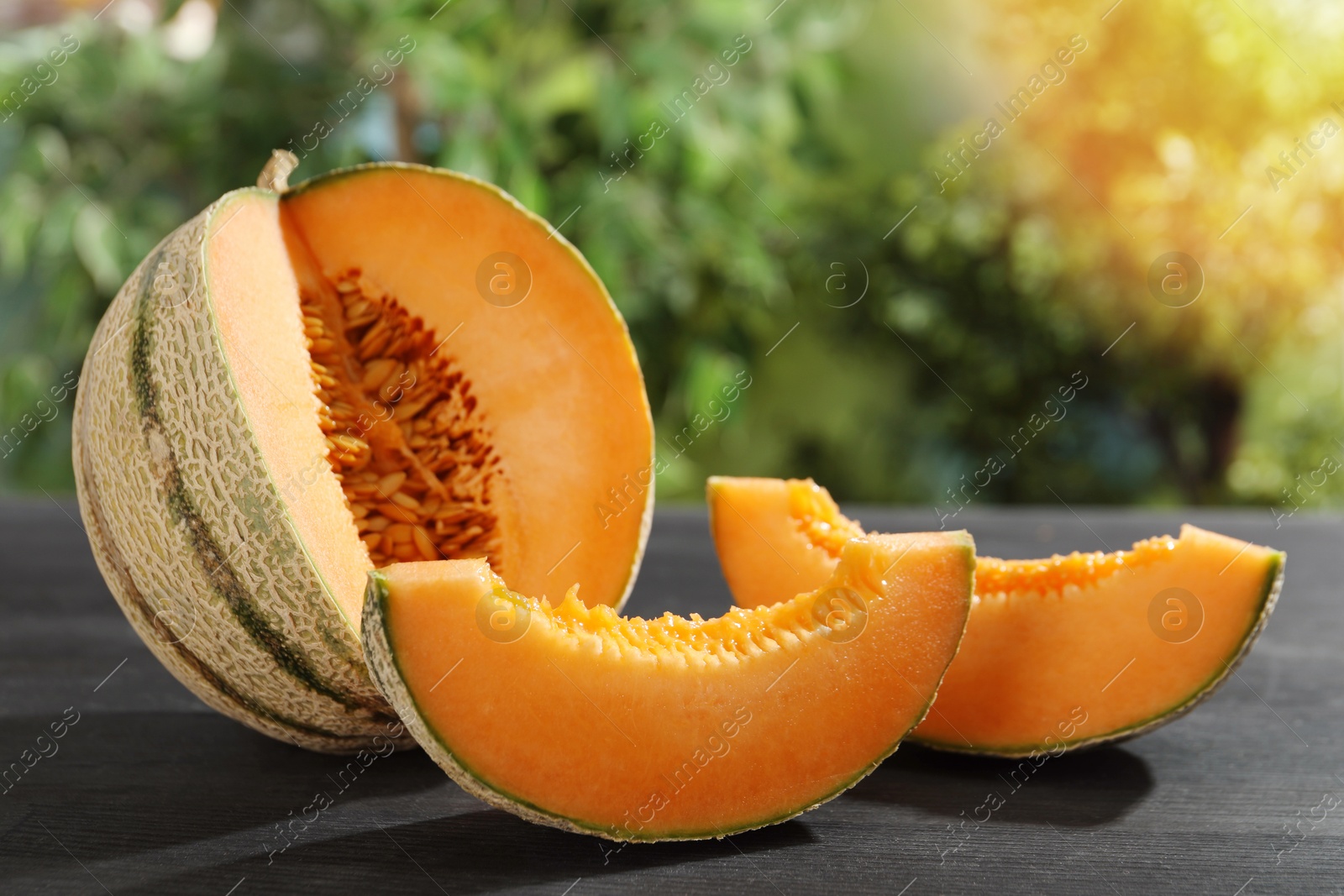 Photo of Fresh ripe Cantaloupe melon on dark wooden table, closeup