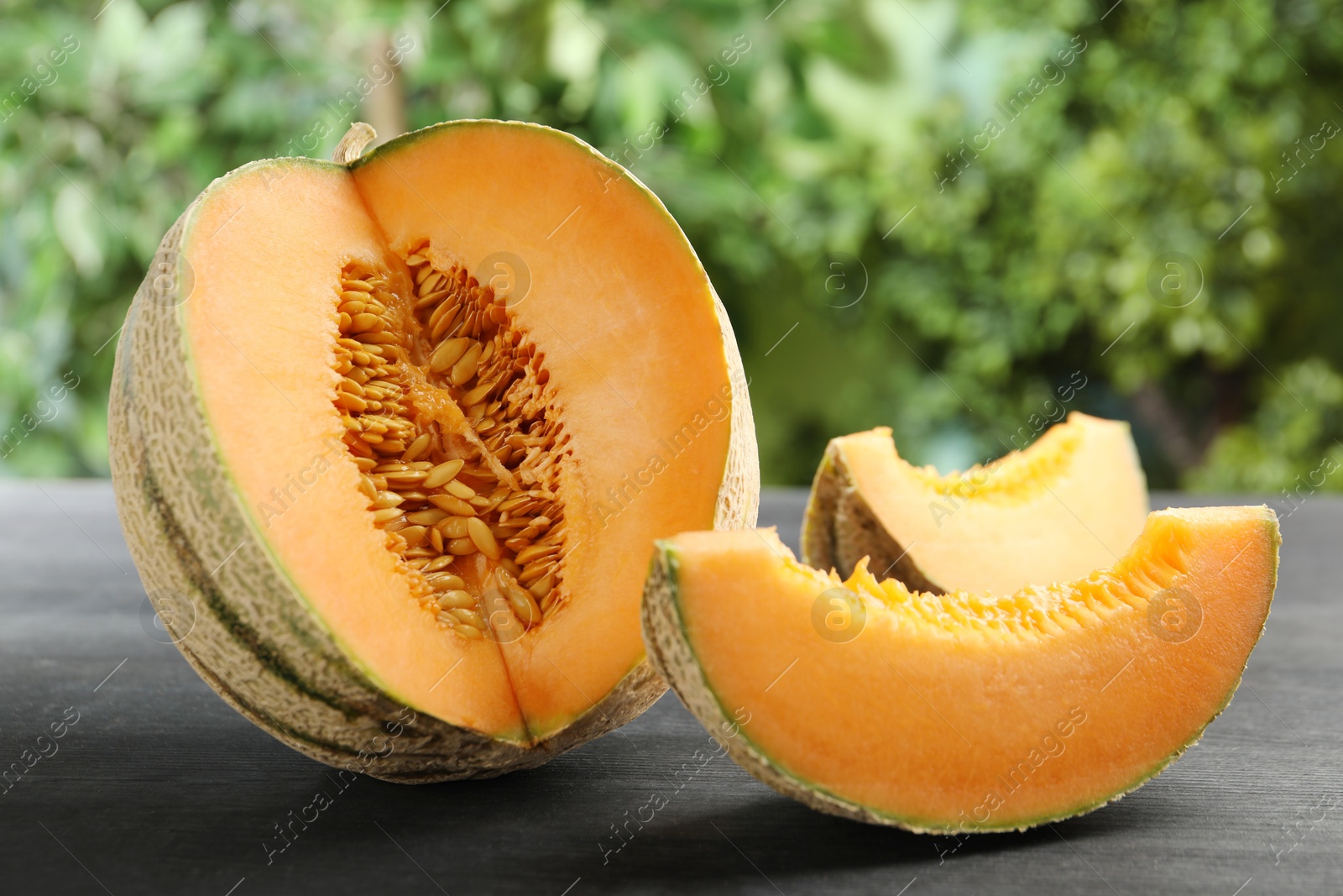 Photo of Fresh ripe Cantaloupe melon on dark wooden table, closeup