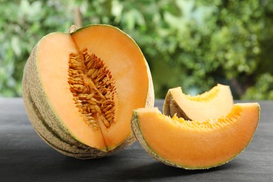 Photo of Fresh ripe Cantaloupe melon on dark wooden table, closeup