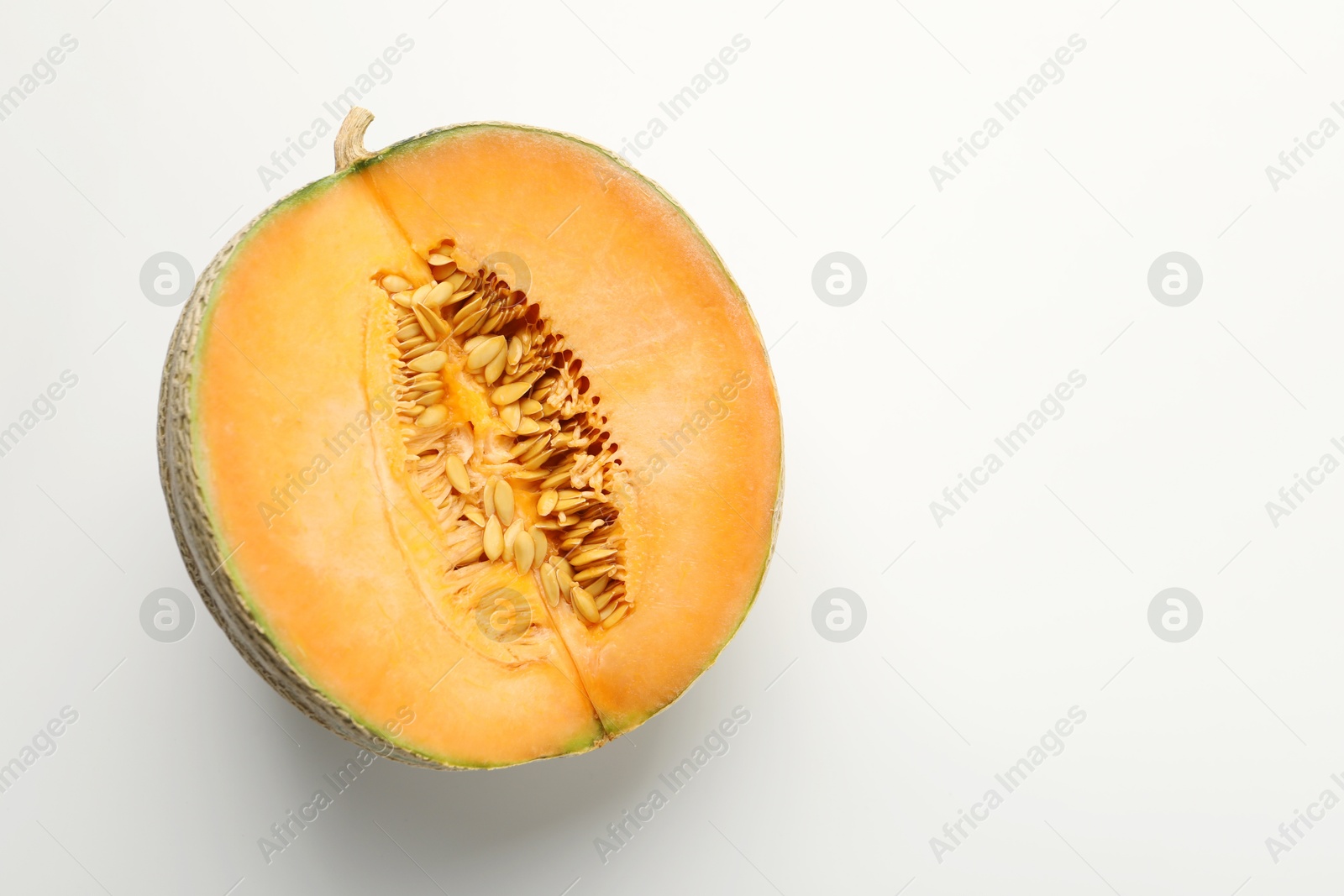 Photo of Half of fresh Cantaloupe melon on white table, top view. Space for text