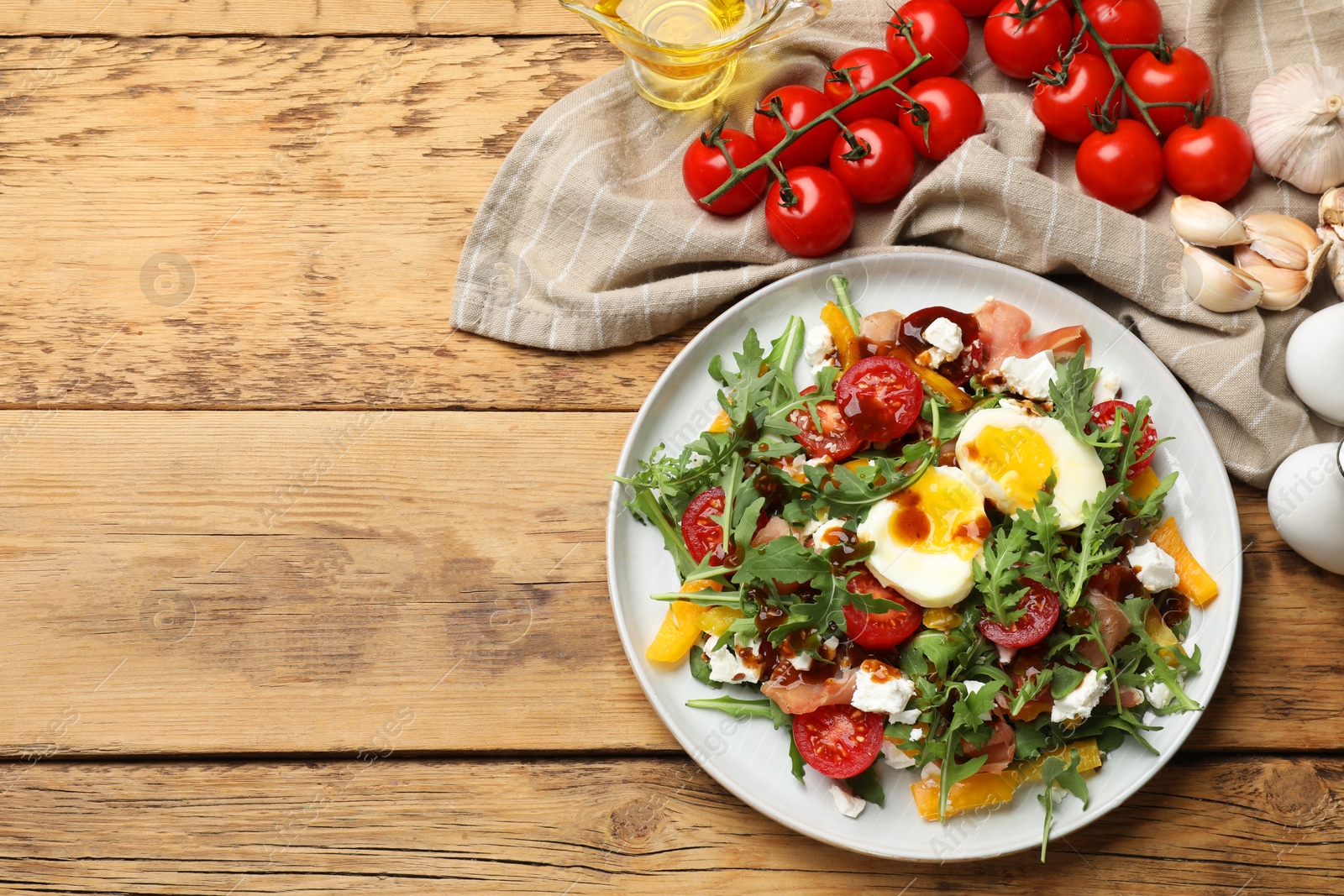 Photo of Tasty salad with arugula, egg, cheese and vegetables on wooden table, flat lay. Space for text