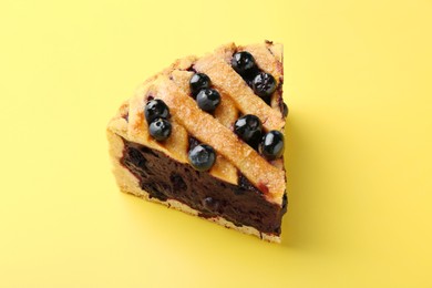 Photo of Slice of homemade blueberry pie on yellow background