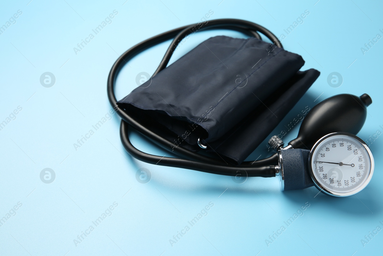 Photo of Blood pressure measuring device on light blue background