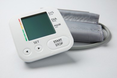 Photo of Blood pressure measuring device on light grey background, closeup