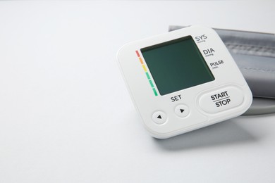 Blood pressure measuring device on light grey background, closeup. Space for text