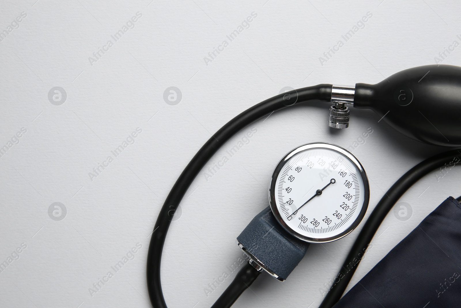 Photo of Blood pressure measuring device on light grey background, top view. Space for text