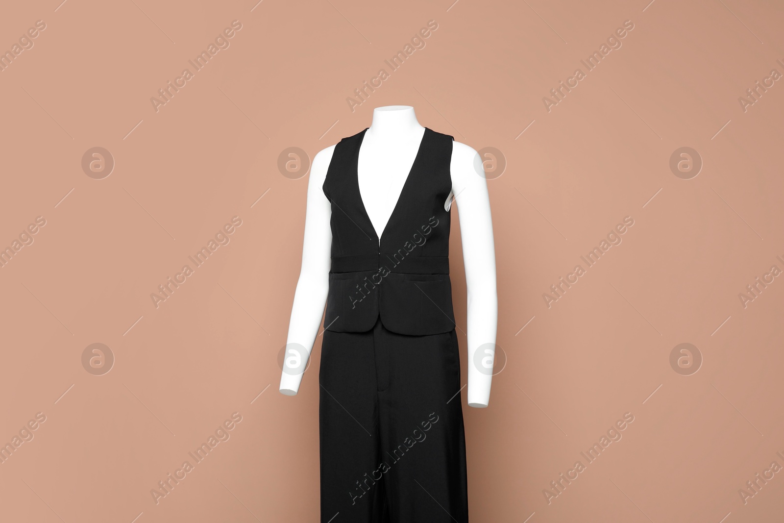 Photo of Female mannequin with stylish black outfit on light brown background