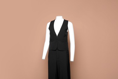 Photo of Female mannequin with stylish black outfit on light brown background