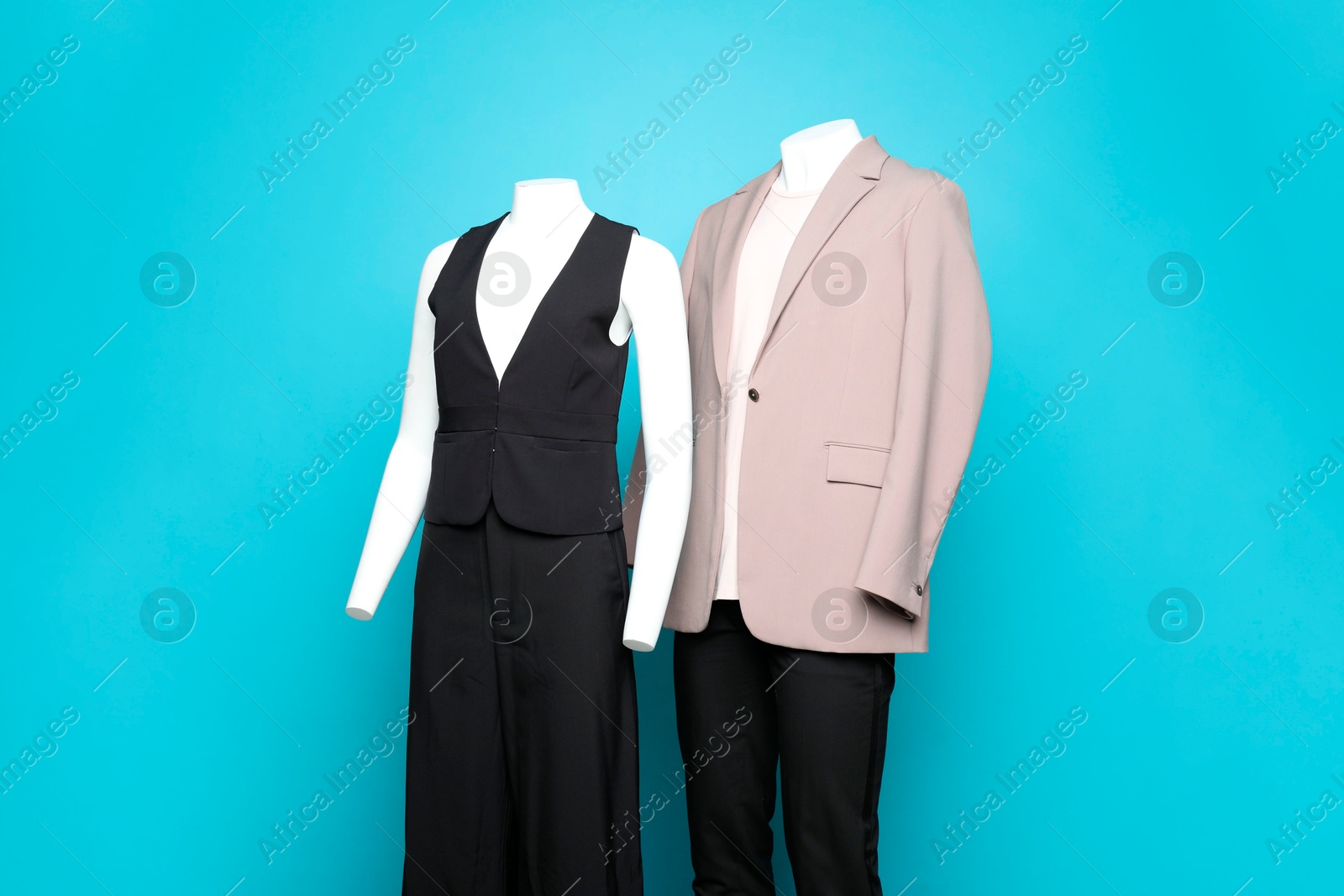 Photo of Female and male mannequins with stylish outfits on light blue background