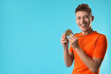 Happy winner with golden medal on light blue background. Space for text