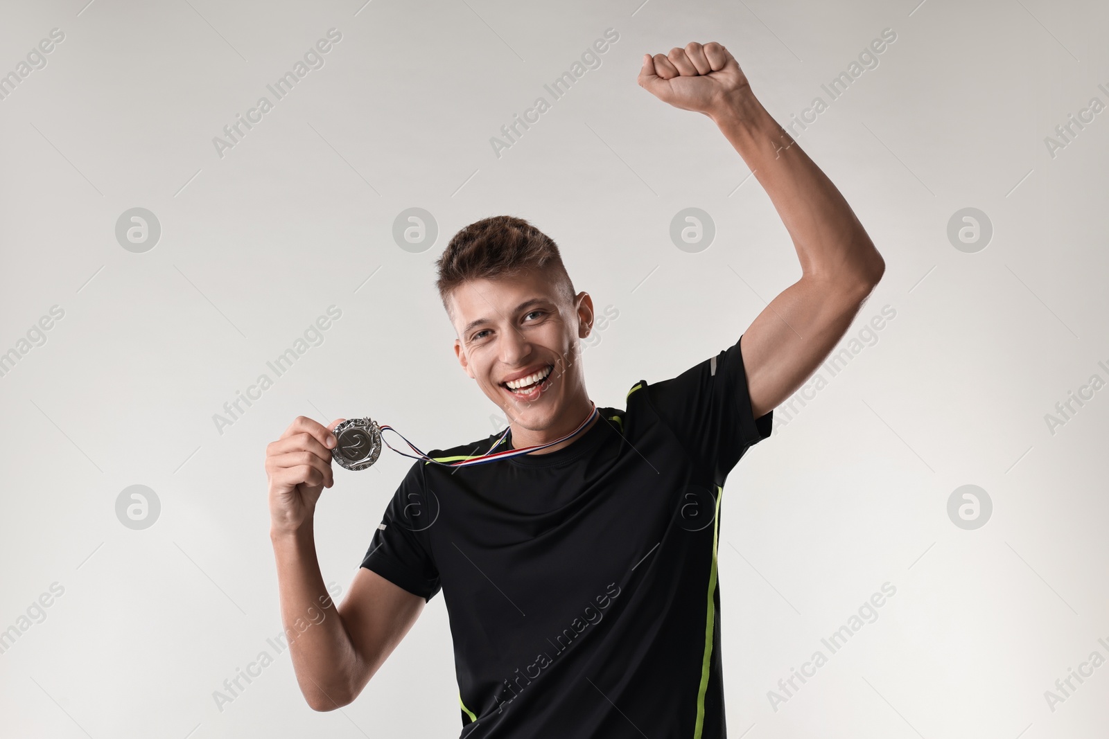 Photo of Happy winner with silver medal on light grey background