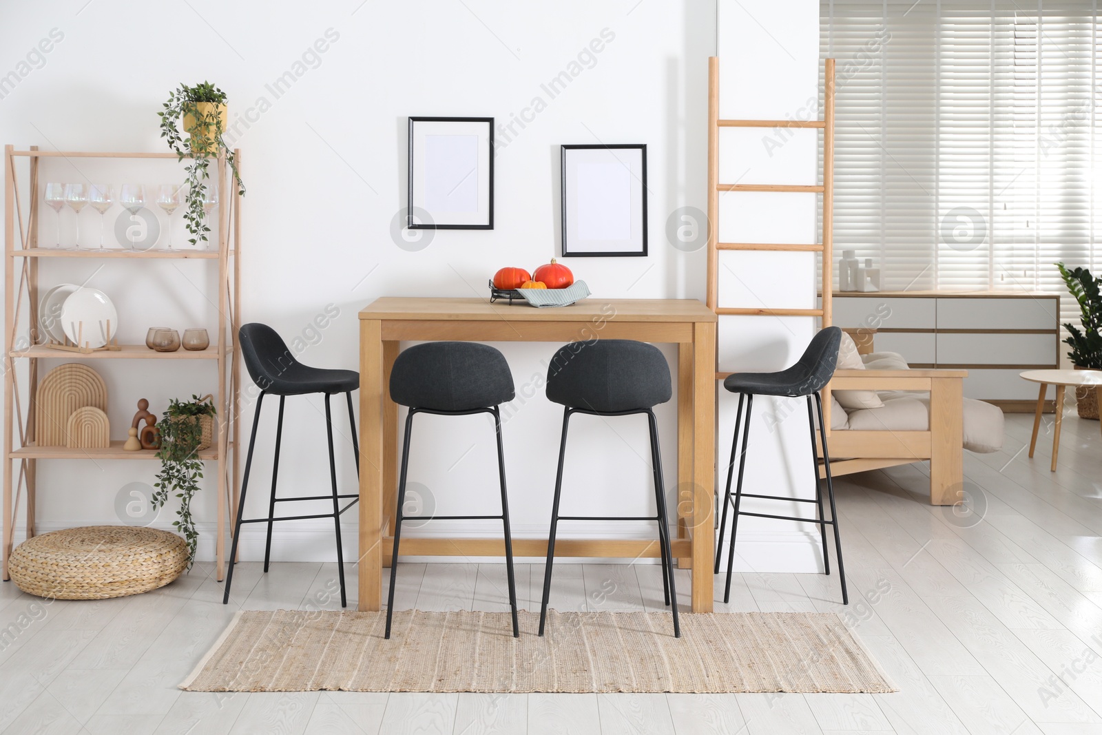 Photo of Bar stools near wooden table in room