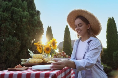 Woman setting table for picnic in garden