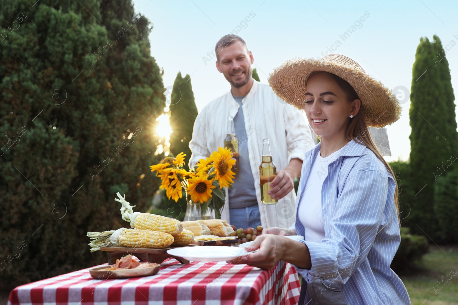 Photo of Friends enjoying picnic at table in garden