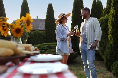 Friends with drinks enjoying picnic in garden