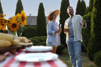 Friends with drinks enjoying picnic in garden