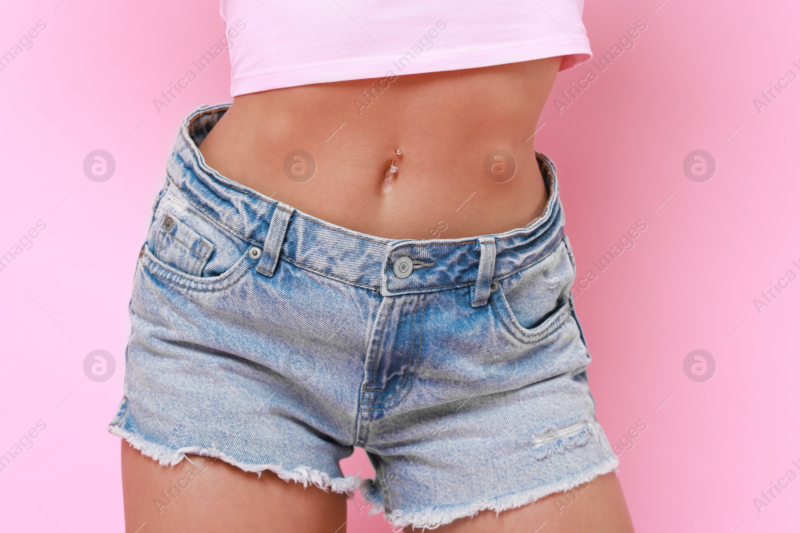 Photo of Woman wearing stylish denim shorts on pink background, closeup