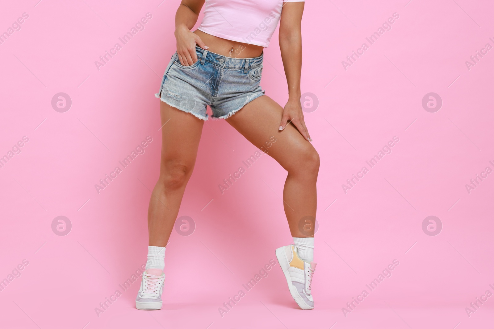 Photo of Woman wearing stylish denim shorts on pink background, closeup