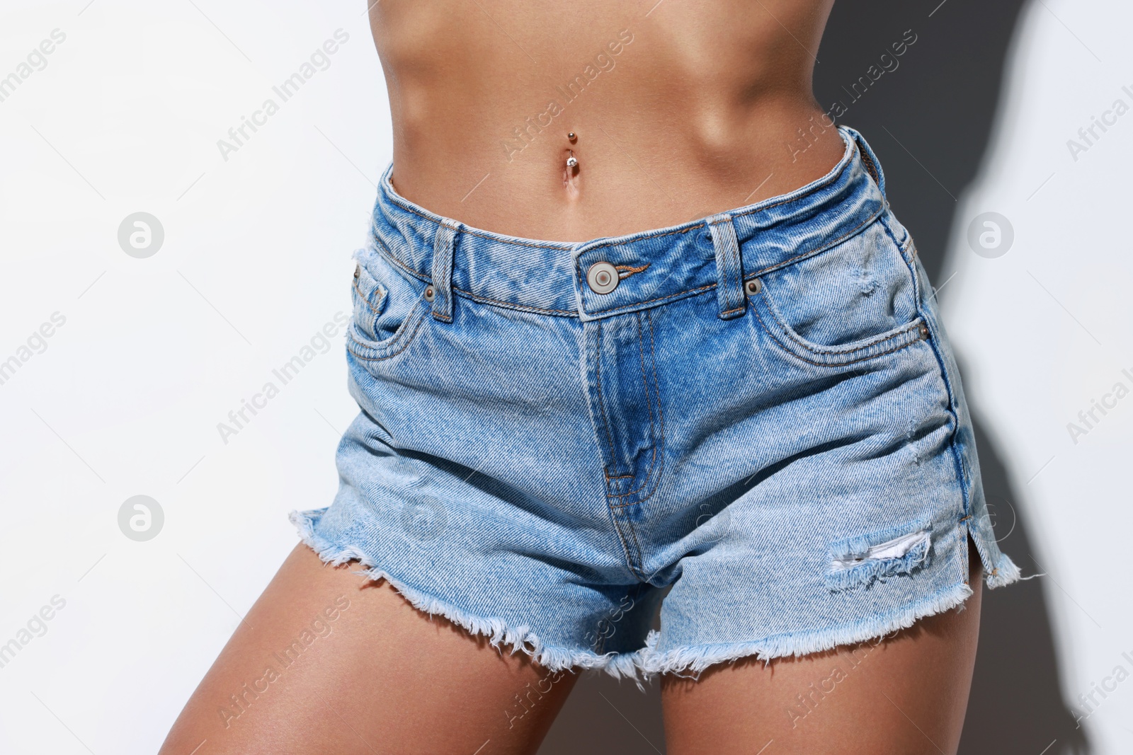 Photo of Woman wearing stylish denim shorts on white background, closeup