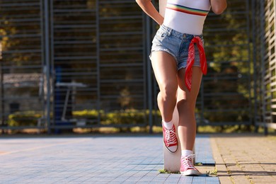 Woman wearing stylish denim shorts outdoors, closeup. Space for text