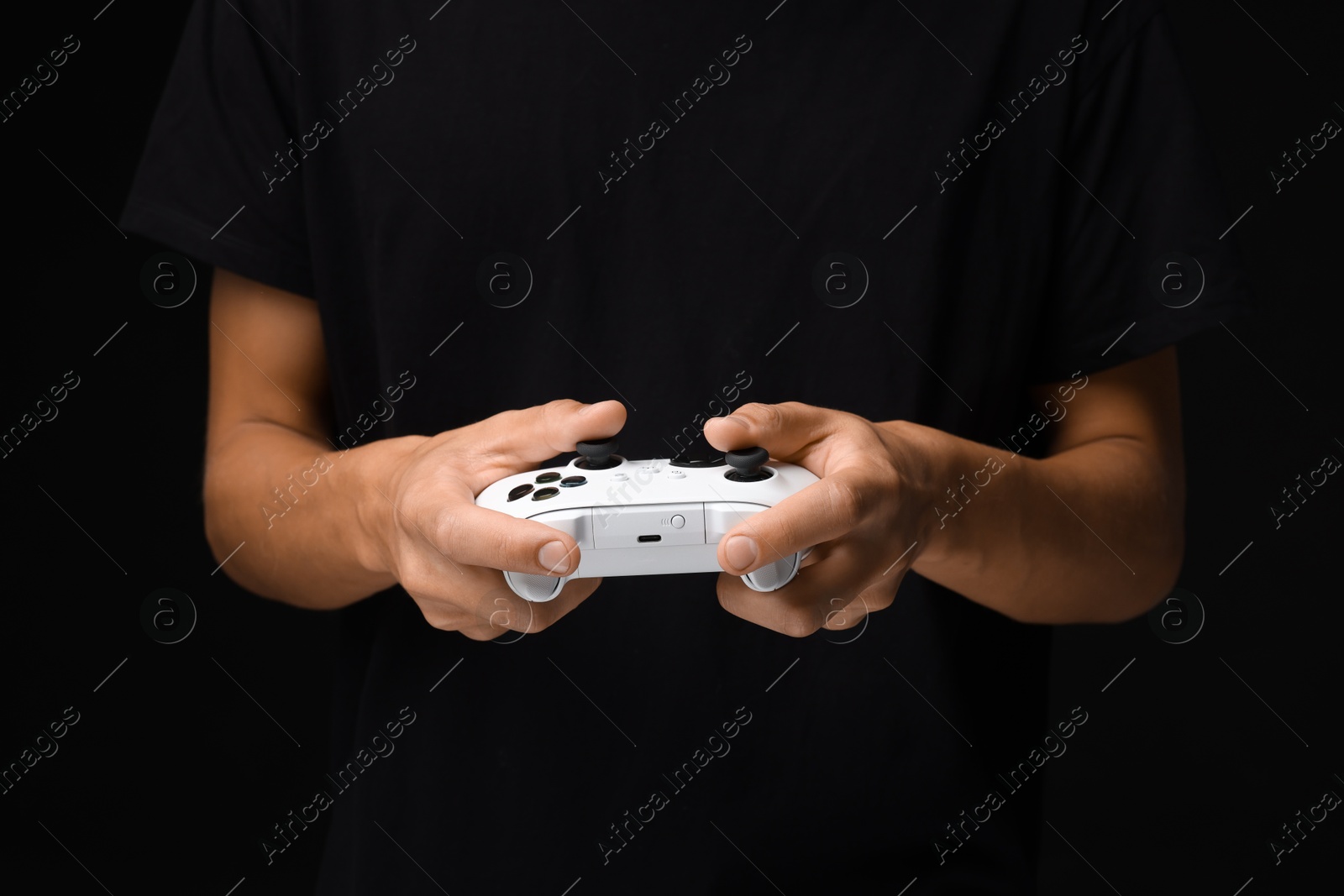 Photo of Man with controller on black background, closeup