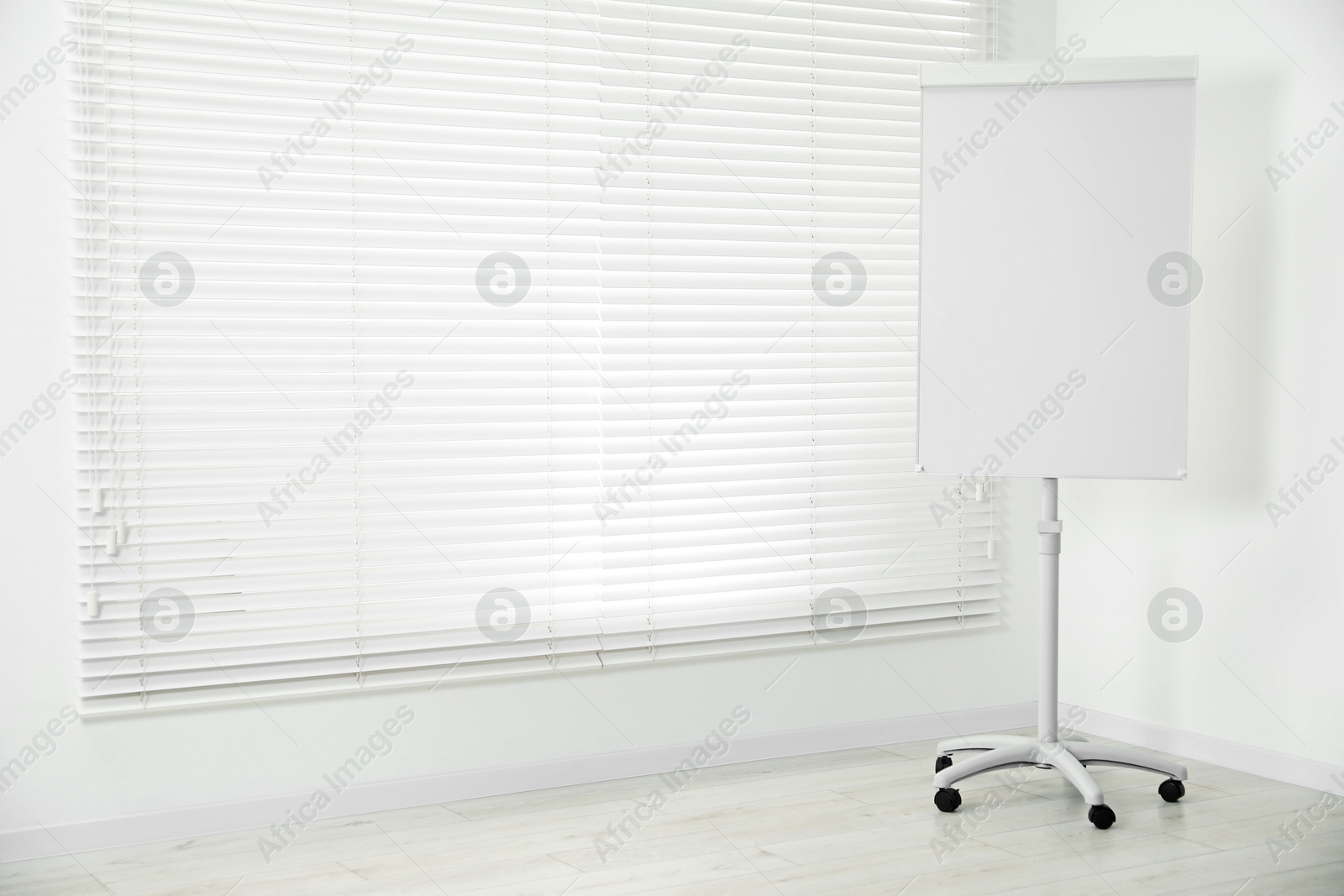 Photo of Flip chart near window in office. Mockup for design