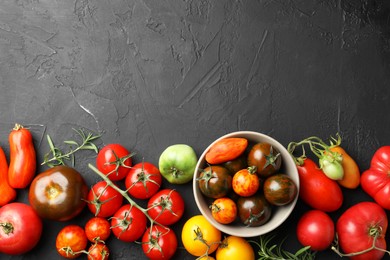 Photo of Different fresh tomatoes and rosemary on grey textured table, flat lay. Space for text