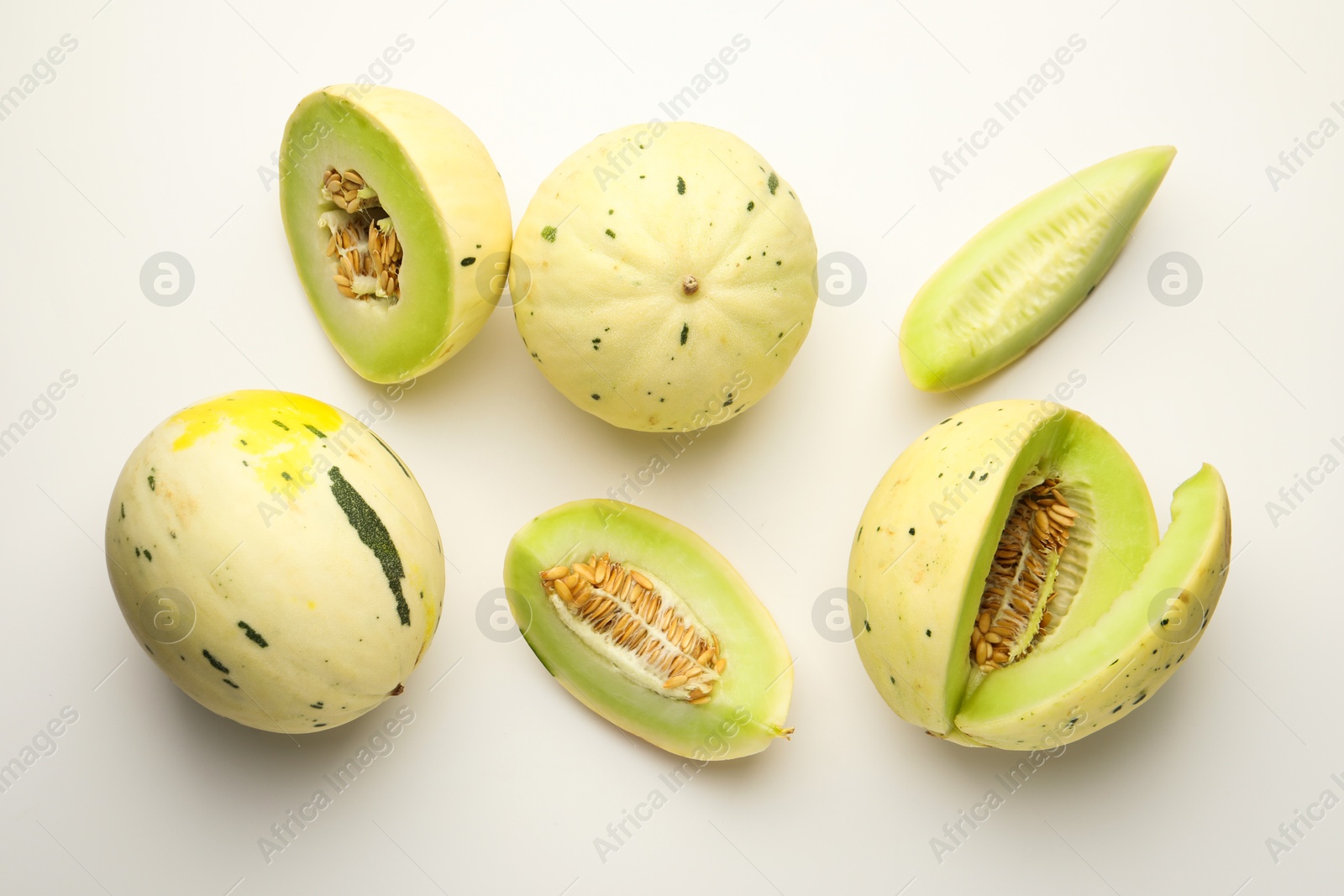 Photo of Fresh ripe honeydew melons on white background, flat lay