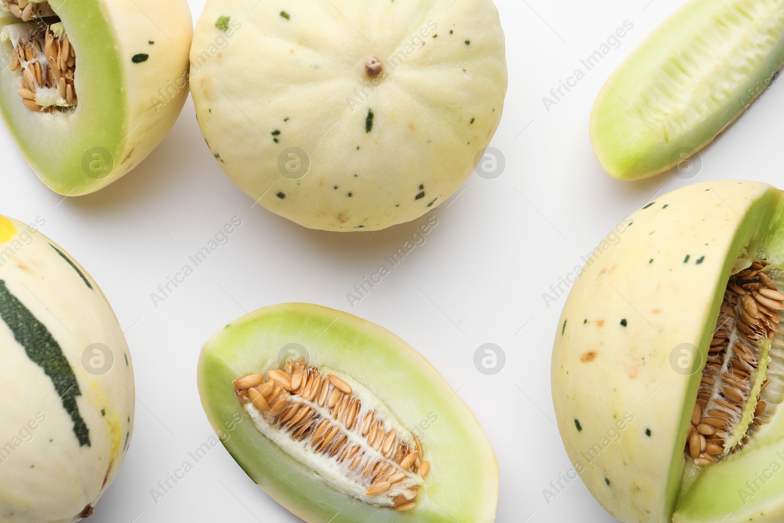 Photo of Fresh ripe honeydew melons on white background, flat lay