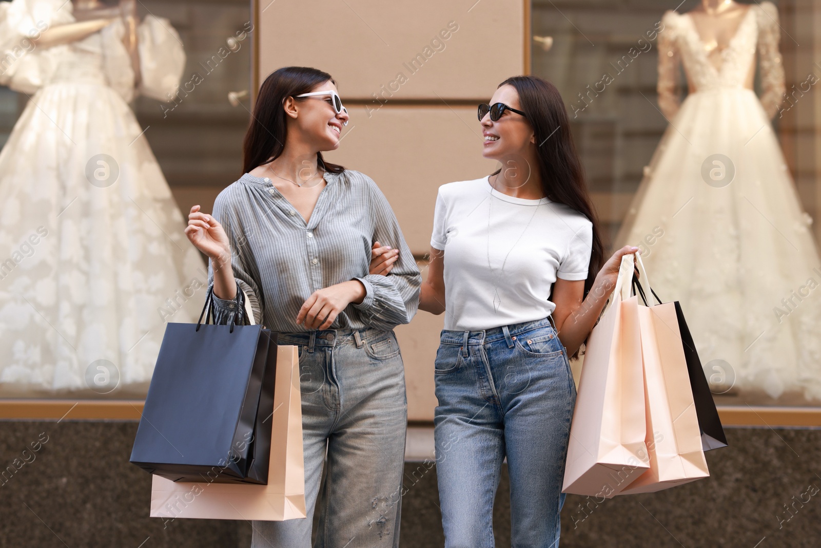 Photo of Happy women with colorful shopping bags outdoors