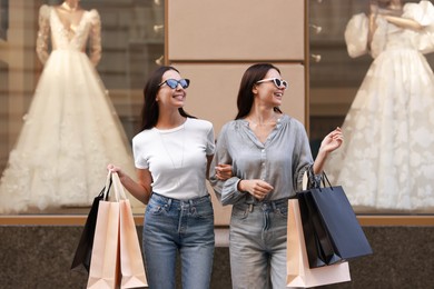 Happy women with colorful shopping bags outdoors