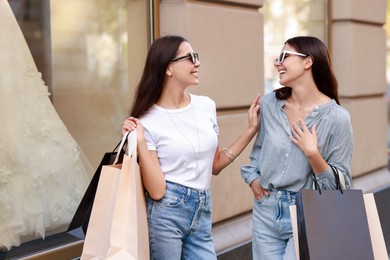 Photo of Happy women with colorful shopping bags outdoors