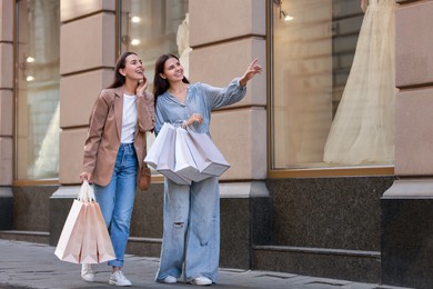 Photo of Happy women with many shopping bags outdoors