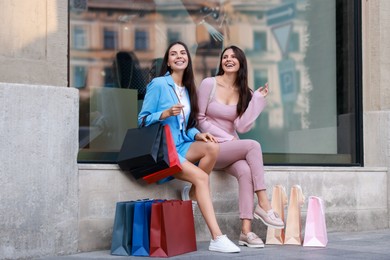 Happy women with colorful shopping bags outdoors