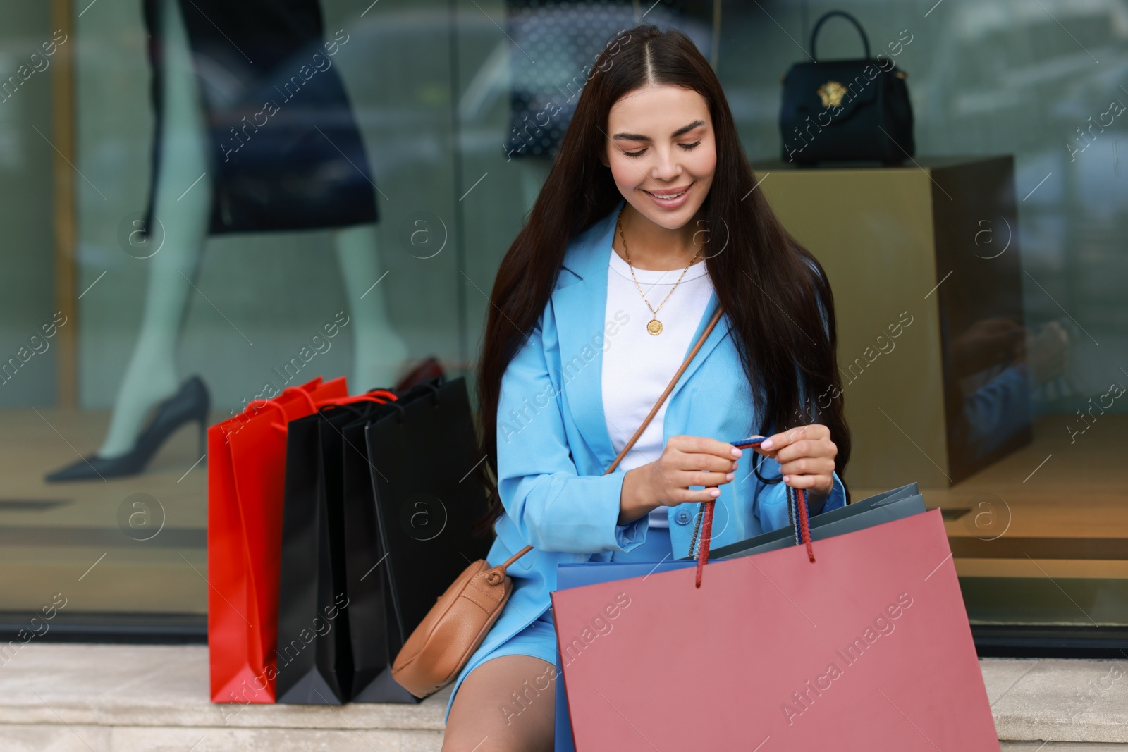 Photo of Happy woman with colorful shopping bags outdoors