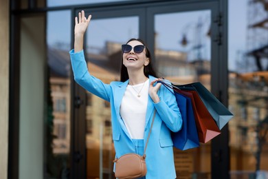 Happy woman with colorful shopping bags outdoors