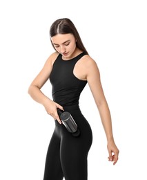 Woman using percussive massager to relieve hip muscles on white background